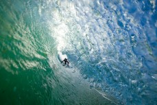 A surfer peers into a tube at Blackhead Beach, Dunedin, New Zealand. 