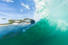 A surfer, shotfrom within the wall of the wave, rides inside the barrel at Blackhead Beach, Dunedin, New Zealand. 