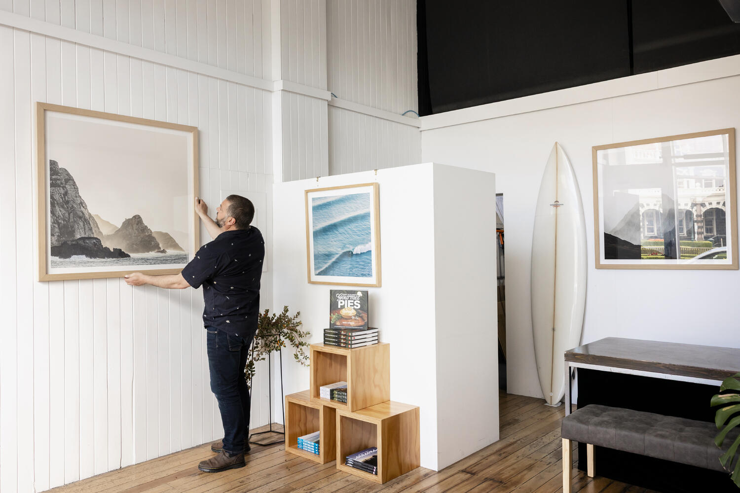 Photographer Derek Morrison hangs a picture in his Box of Light Gallery. 