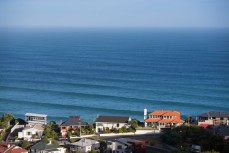 Lines of swell wrap into Seconds Beach below Cliffs Road, Dunedin, New Zealand. 