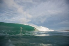 Ben rides a barreling wave during a surf at a beach in Raglan, Waikato, New Zealand. 