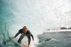 Aaron Morrison rides a barrel during a surf at a beach in Raglan, Waikato, New Zealand. 