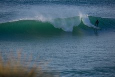 A surfer rides a wally wave at Blackhead Beach, Dunedin, New Zealand. 