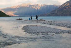 Tourists enjoy the views across Lake Wakatipu at a campground at 12 Mile Delta near Queenstown, New Zealand. 