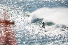 A travelling surfer rides a windblown wave at St Clair Point, Dunedin, New Zealand. 