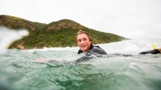 Nick Rapley paddles out to the peak at a remote beach on Otago Peninsula, Dunedin, New Zealand. 
