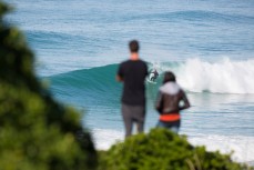 Onlookers watch as Tim Barton rides a wave on a peaky east swell at Blackhead Beach, Dunedin, New Zealand. 