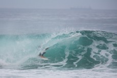 A surfer rides a tube at St Kilda Beach, Dunedin, New Zealand. 