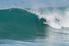 A surfer getrs barreled in playful conditions at Blackhead Beach, Dunedin, New Zealand. 