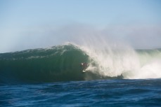 Leroy Rust tucks into the wall on a warping section at a remote reef break near Dunedin, New Zealand. 