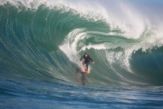Davy Wooffindin surfs a large peak on a remote reef break near Dunedin, New Zealand. 