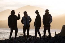 Band members from Summer Thieves hangout at Blackhead Beach on dusk, Dunedin, New Zealand. 
