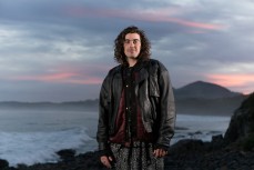 Band members from Summer Thieves hangout at Blackhead Beach on dusk, Dunedin, New Zealand. 