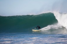 A surfer rides a wave at St Clair Point, Dunedin, New Zealand. 