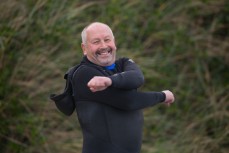 Graham Dickie limbers up before a surf at Blackhead Beach, Dunedin, New Zealand. 