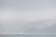 Rain showers shroud the north coast of Raglan, New Zealand. 
