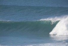 Nick Smart rides a large wave at a reef break in the Catlins, Southland, New Zealand. 