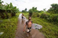 Brett Wood (front) and Kent Inglis wade through floodwaters on the way to Boulders near Salani, Samoa. 