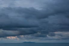 Mayor Island lies like a crocodile on the horizon at Mount Maunganui, New Zealand. 
