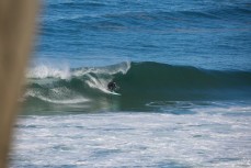 A surfer rides a hollow wave at Blackhead Beach, Dunedin, New Zealand. 