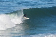 A surfer rides a hollow wave at Blackhead Beach, Dunedin, New Zealand. 