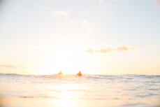 Surfers watch the sunrise as they wait for waves produced from a southeast ground swell at a beach near Mount Maunganui, Bay of Plenty, New Zealand. 