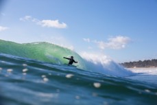 A surfer turns under the lip on a wave at Matakana Island, Mount Maunganui, Bay of Plenty, New Zealand. 