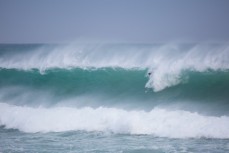 A surfer takes off late on a big, wild swell at St Clair Beach, Dunedin, New Zealand. 