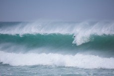 A surfer takes off late on a big, wild swell at St Clair Beach, Dunedin, New Zealand. 