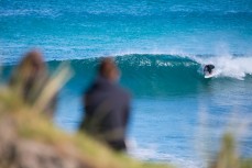 Onlookers watch at Davy Wooffindin tucks into a little barrel at Blackhead Beach, Dunedin, New Zealand. 