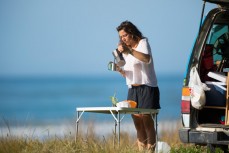 Adele, from Paris, prepares coffee at her campsite at Makarori Beach, Gisborne, Eastland, New Zealand. 