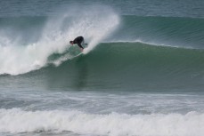 A surfer rides a perfect wall at Aramoana Beach, Dunedin, New Zealand. 