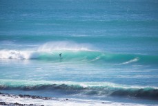 A surfer rides a clean offshore wave at a remote point in the Catlins, Southland, New Zealand. 