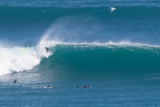 A surfer drops into a clean offshore wave at a remote point in the Catlins, Southland, New Zealand. 