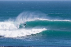 A surfer rides a barrel on an offshore wave at a remote point in the Catlins, Southland, New Zealand. 