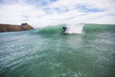 A surfer lines up a little barrel section at Blackhead Beach, Dunedin, New Zealand. 