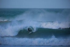 A surfer turns on a wall in fun waves at Aramoana, Dunedin, New Zealand. 