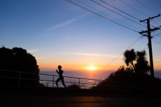 A runner jogs up Ravenswood Road at dawn, St Clair, Dunedin, New Zealand. 