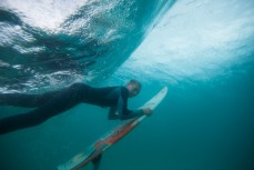 Jack Mcleod duckdives beneath a wave in the fun, glassy conditions at Blackhead Beach, Dunedin, New Zealand. 