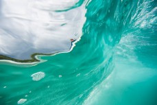 Patterns and textures of a wave as a surfer takes off in fun, glassy conditions at Blackhead Beach, Dunedin, New Zealand. 