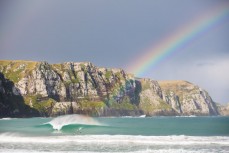 A rainbow illuminates the peak at a remote beach in the Catlins, Southland, New Zealand. 