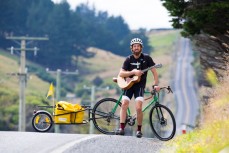 Musician Monty Bevins ahead of his nationwide cycle tour of New Zealand on the road to Blackhead Beach, Dunedin, New Zealand. 