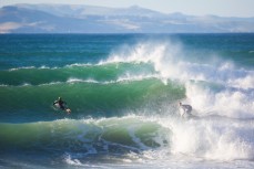 A surfer drives off the bottom on a wave at Whareakeake, Dunedin, New Zealand. 
