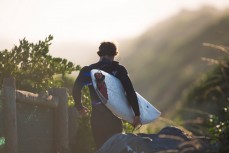 Jamie Civil heads for a surf at Blackhead Beach, Dunedin, New Zealand. 