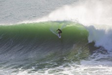 Davy Wooffindin making the most of big waves from Cyclone Pam at a remote point break on the North Coast of Dunedin, New Zealand. 