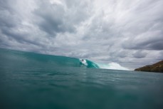Brett Wood drops into a wave during a new swell at a beach near Raglan, New Zealand. 