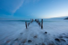 Swirling water around the poles at St Clair Beach, Dunedin, New Zealand. 