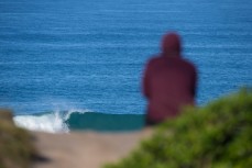 An onlooker watches a breaking wave at Blackhead Beach, Dunedin, New Zealand. 