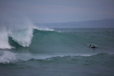 A surfer paddles for a rampy peak at Blackhead Beach, Dunedin, New Zealand. 