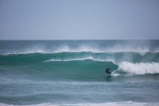 A young surfer rides a wave at Blackhead Beach, Dunedin, New Zealand. 